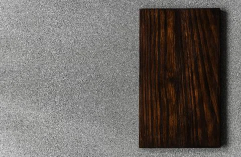 Background of grey stone texture and pattern with brown wooden cutting board. Stock Photos