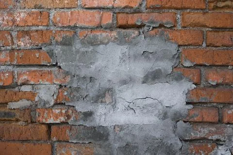 Background of grunge red brick wall with cocnrete patch  . close up view Stock Photos