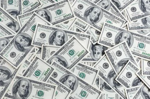 A background of hundred dollars scattered on the table. Stock Photos