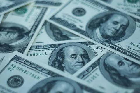A background of hundred dollars scattered on the table. Stock Photos