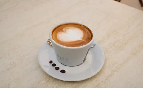 Background image of cappuccino in a cup with coffee beans Stock Photos