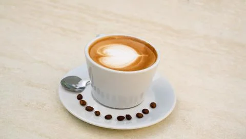 Background image of cappuccino in a cup with coffee beans Stock Photos