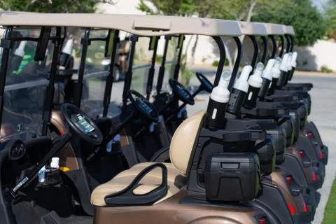 Background image of Golf carts parked on a golf closure in a line. Stock Photos