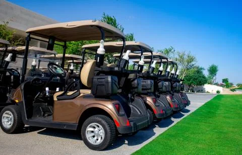 Background image of Golf carts parked on a golf closure in a line. Stock Photos