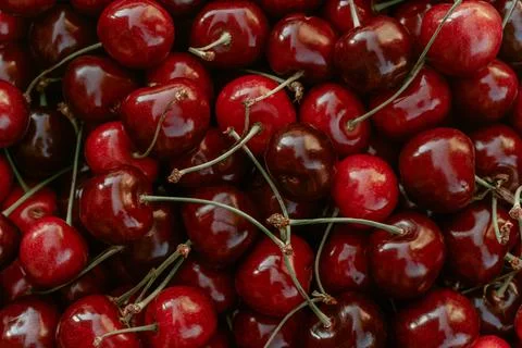 Background image of lying red ripe sweet cherries. Top view, flat lay. Copy Stock-Fotos