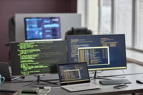 Background image of multiple computer screens with code lines at desk Stock Photos