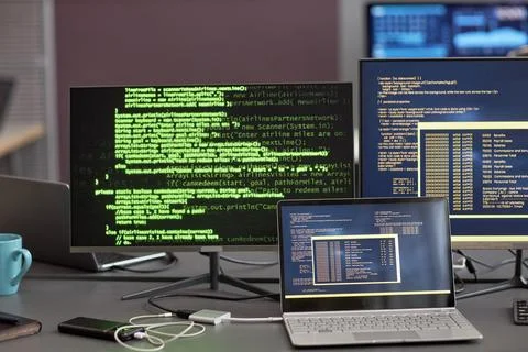 Background image of multiple computer screens with green code lines at workplace Stockfoto's
