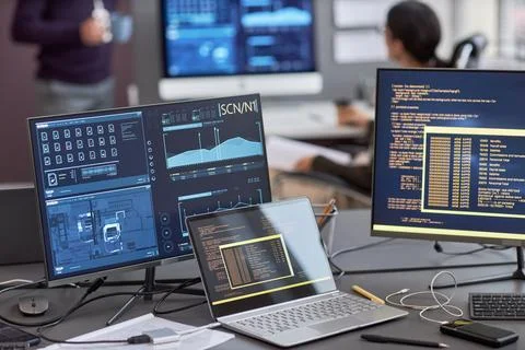 Background image of multiple computer screens with data and code Stock Photos