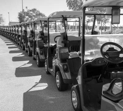 Background image of multiple golf carts parked in order. Photos