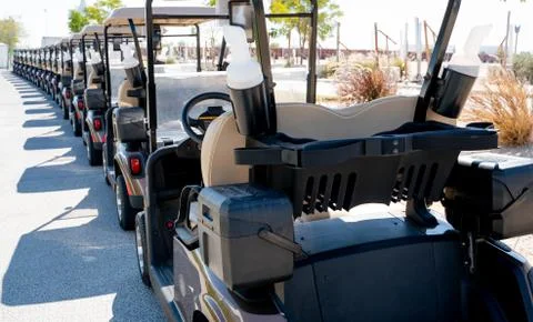 Background image of multiple golf carts parked in order. Stock Photos