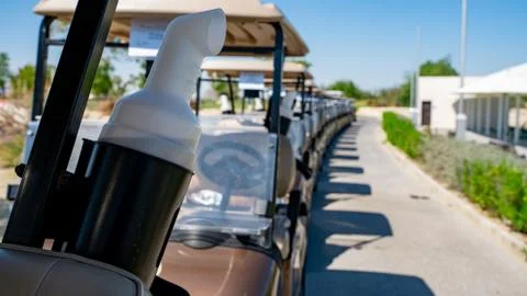 Background image of multiple golf carts parked in order. Stock Photos