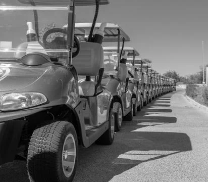 Background image of multiple golf carts parked in order. Photos