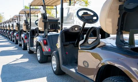 Background image of multiple golf carts parked in order. Photos