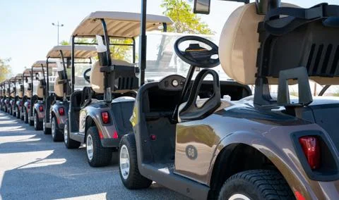 Background image of multiple golf carts parked in order. Stock Photos