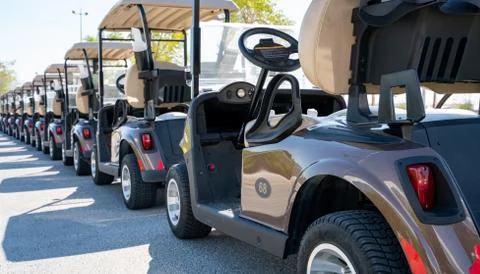 Background image of multiple golf carts parked in order. Stock Photos