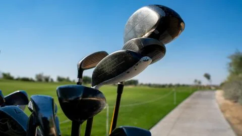 Background image of multiple golf sticks on the behind of a golf cart. Photos