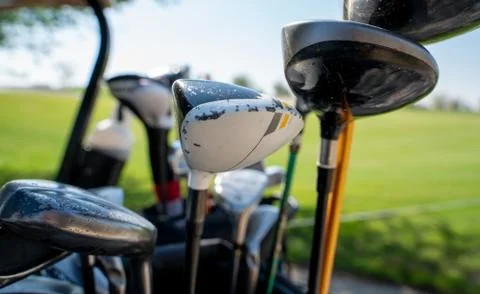 Background image of multiple golf sticks on the behind of a golf cart. Stock Photos