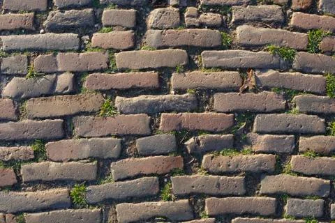 Background image of old brickstone road backlit with low sunligh Stock Photos