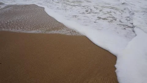 Background image pattern of sea shore with sea waves on sand Stock Photos