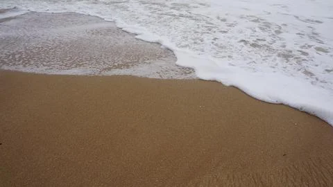 Background image pattern of sea shore with sea waves on sand Stock Photos