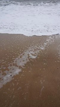 Background image pattern of sea shore with sea waves on sand Stock Photos