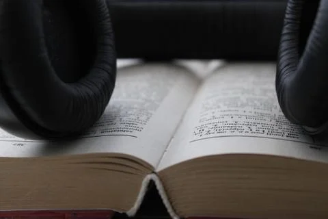 A background image that shows large, black wired headphones and other items. Stock Photos