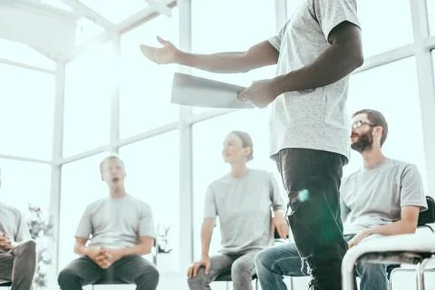 Background image of a speaker reading a report to a group of students. Stock Photos
