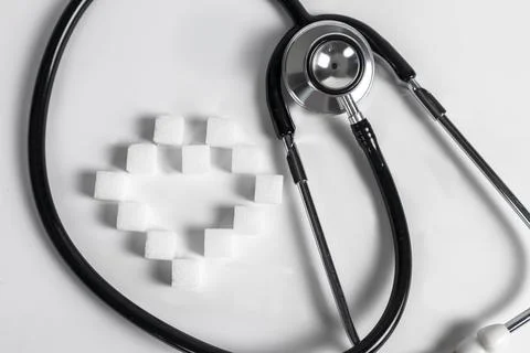 Background image of sugar cubes and medical stethoscope health care Stock Photos