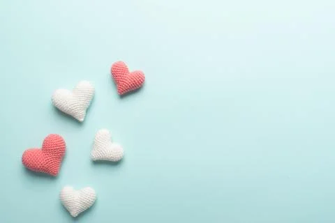 Background of knitted hearts on a light blue background for Valentine's Day. Stock Photos