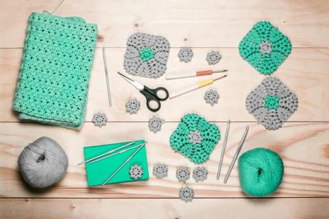 Background with knitting tools and accessories. Green crocheted square napkin Stock Photos