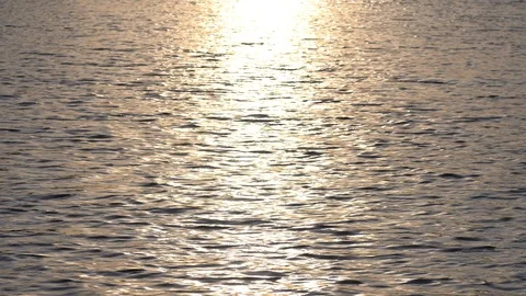 Background of lake water surface with ripples and sunlight at sunset or sunrise. Video stock 125870228