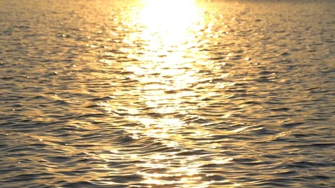 Background of lake water surface with ripples and sunlight at sunset Stockbeeldmateriaal 128232252