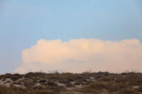 Background landscape of blue sky with clouds over cracked desert earth Stock Photos