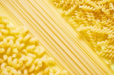 Background layout of pasta. Spirals, spaghetti, twisted horn. Stock Photos