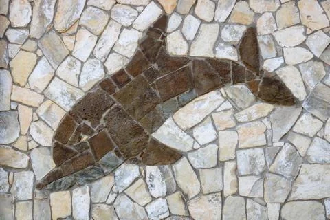 Background of light-colored stone with brown Dolphin.The design of the exteri Stock Photos