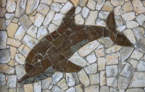 Background of light-colored stone with brown Dolphin.The design of the exteri Stock Photos