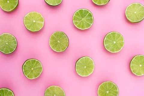 Background of limes split in half on purple background Stock Photos