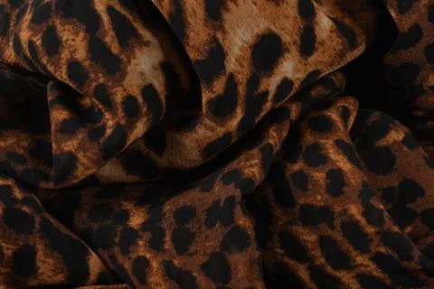 Background made of fabric with a leopard pattern. The cloth is brown with bla Stock Photos