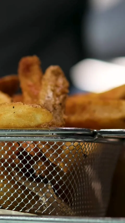 In the background a man brings a glass of Cola crispy fries served in a metal Stock Footage 323924861