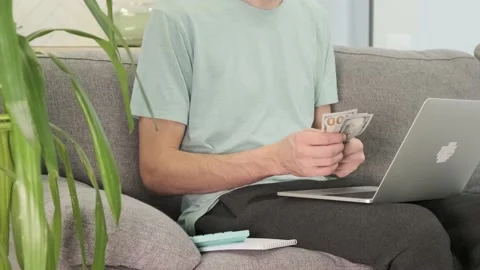 In the background, a man calculates an entry in a laptop Stock Footage 168082048