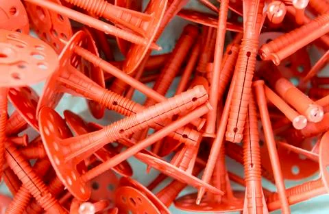 Background of many red plastic dowels for thermal insulation. Stock Photos