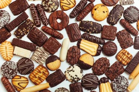 Background of mixed biscuits covered with milk, dark and white chocolate Stock Photos