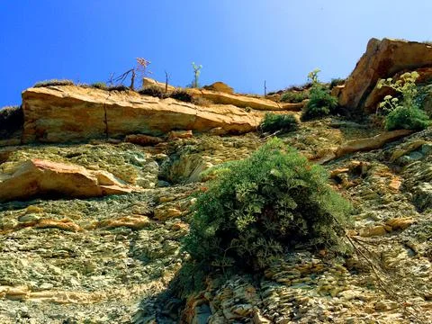 Background with mountain or hill with rocks and blue sky Stock Photos