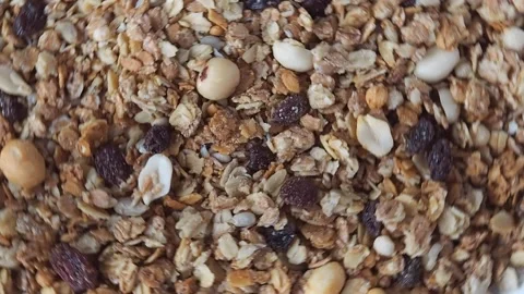 Background muesli oat flakes nuts and raisins rotates. The concept of healthy ea Video stock 228690894