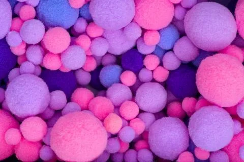 Background from multi-colored pom-poms of different sizes. Stock Photos