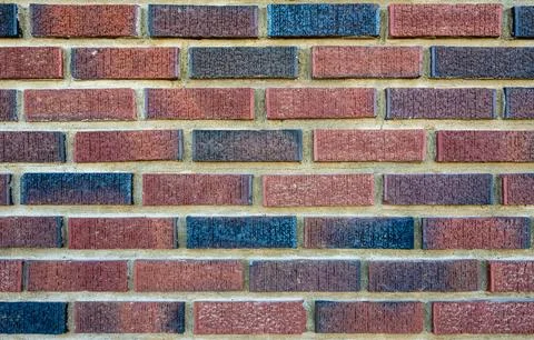 Background of multi-colored red bricks creating a rectangular pattern Stock Photos