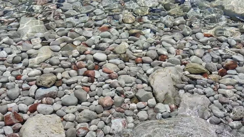 Background with multi-colored stones under clear water on a sunny day. Stock Footage 239505470