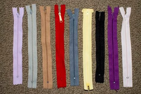 Background of multi-colored zippers for clothes. Stock Photos