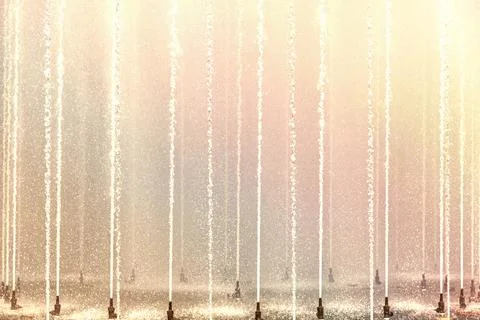 Background of multicolored jets and splashes of a fountain in the park Foto stock