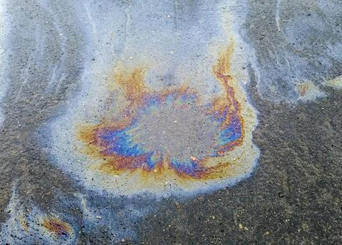 Background of multicolored spots from spilled engine oil Stock Photos